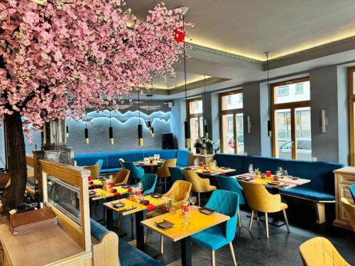 a restaurant with tables and chairs and pink flowers at Gasthause Zur Krone Hotel in Leimen