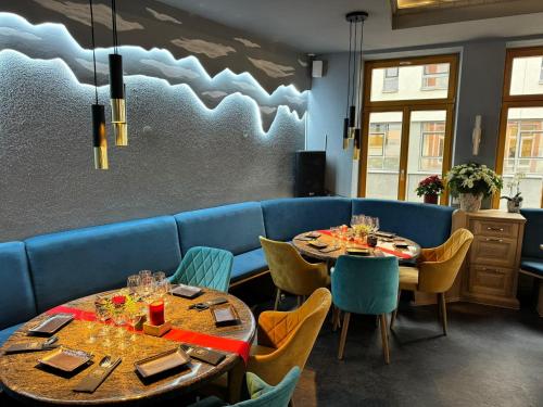 a dining room with two tables and a blue couch at Gasthause Zur Krone Hotel in Leimen