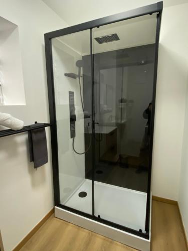 a glass shower in a room with a wooden floor at 012-Superbe étage spacieux avec balcon extérieur netflix gratuit in Charleroi