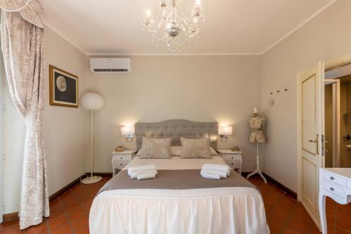 a bedroom with a large bed and a chandelier at Il Torrione in Castiglione del Lago