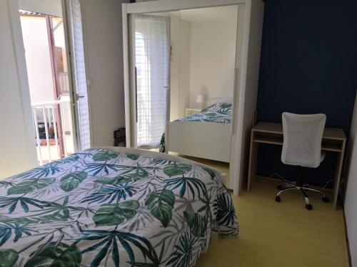 a bedroom with a bed and a desk and a chair at Charmant appartement vue mer au Cap d'Agde in Cap d'Agde