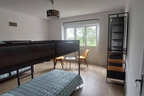 - une chambre avec des lits superposés, une table et des chaises dans l'établissement La Bessonnette proche Puy du Fou, à Chambretaud