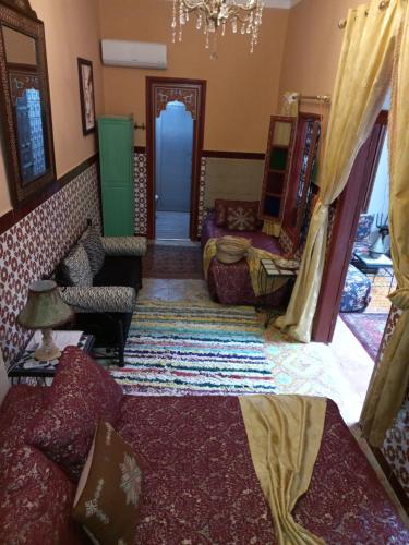 a living room filled with furniture and a chandelier at Dar Pa Labzioui in Meknès