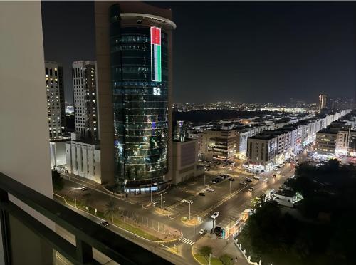 Heart of Abu Dhabi - Wonder Balcony Room في أبوظبي: أفق المدينة في الليل مع مبنى طويل