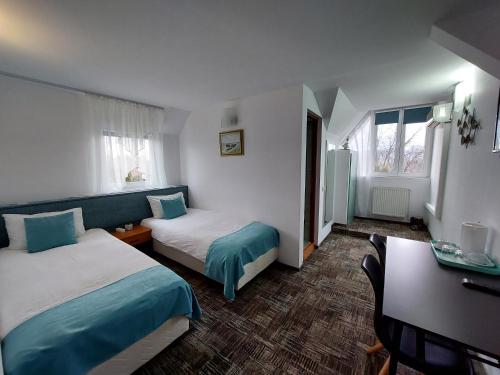 a hotel room with two beds and a desk at Pension Casablanca in Câmpina