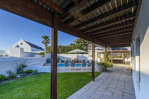 uma vista para o quintal de uma casa com uma pérgola de madeira em Moana Bay em Kommetjie