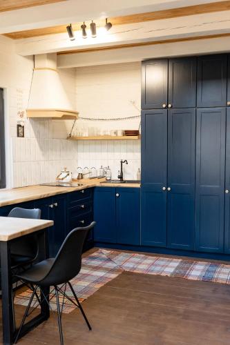 a kitchen with blue cabinets and a table with chairs at Chili Shale in Yablunytsya