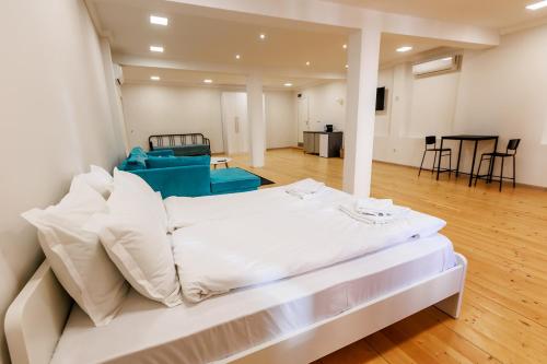 Cama blanca grande en habitación con suelo de madera en А4 XL Studio Saffron en Plovdiv