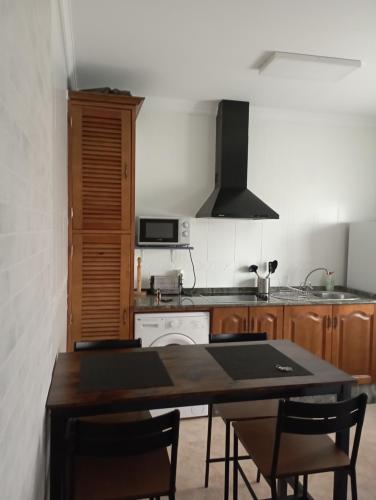 uma cozinha com uma mesa com cadeiras e um fogão em El 20 em Barbate