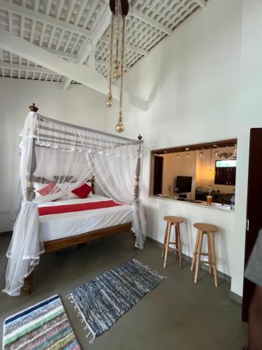 Schlafzimmer mit einem Bett mit Moskitonetz in der Unterkunft Ceylon Little Paradise in Hikkaduwa