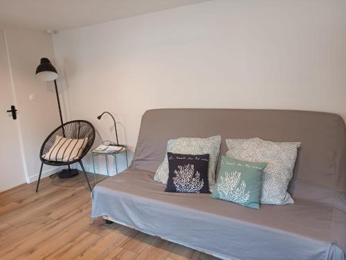 un lit avec trois oreillers dessus dans l'établissement Maison studio proche mer, à Pordic