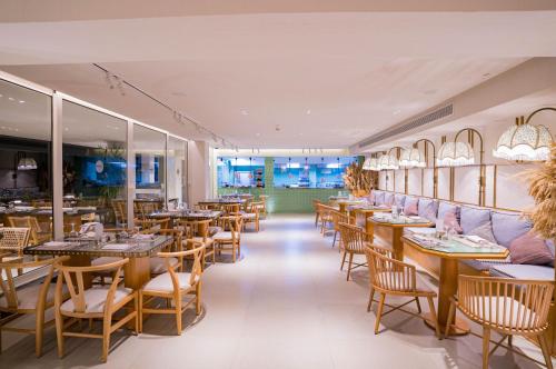 a restaurant with wooden tables and chairs and windows at Marina Sharm Hotel in Sharm El Sheikh