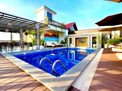 a swimming pool in front of a house at Le Vert Angkor Hotel in Siem Reap