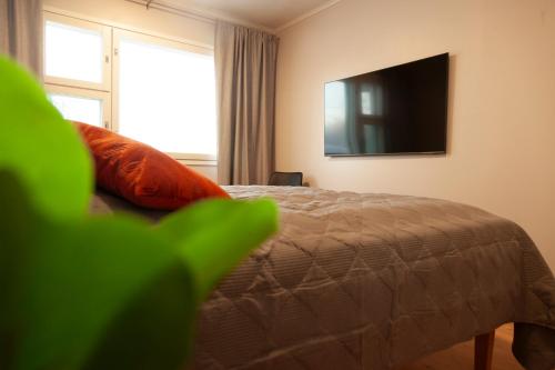 a bedroom with a bed with a television on the wall at Saimaan Kodikas Premium in Savonlinna