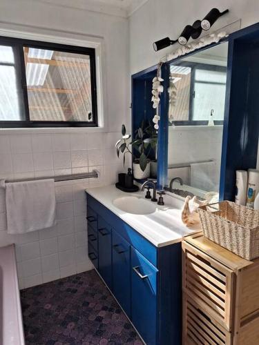 a bathroom with a blue sink and a mirror at Clear Sand in Forster