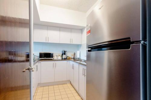 a stainless steel refrigerator in a kitchen with white cabinets at Carey Beach Villa in Humacao
