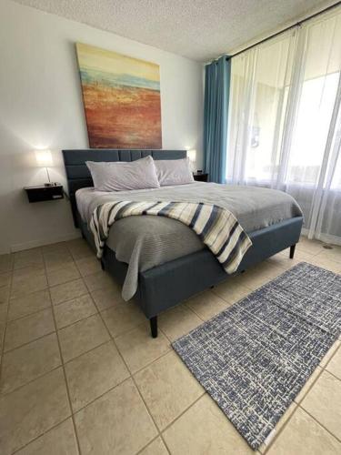 a bedroom with a bed with a painting on the wall at Carey Beach Villa in Humacao