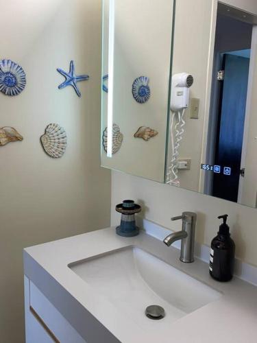 a white bathroom with a sink and a mirror at Carey Beach Villa in Humacao