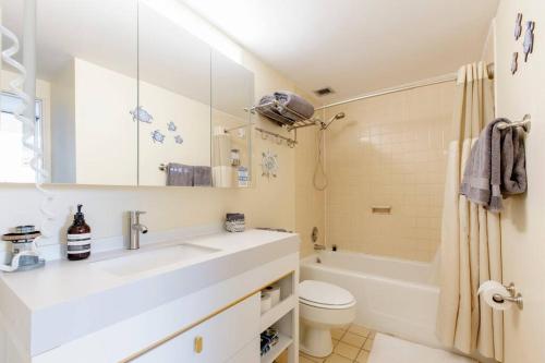 a bathroom with a sink and a toilet and a tub at Carey Beach Villa in Humacao
