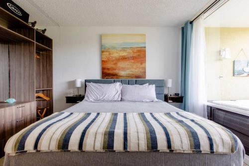 a bedroom with a large bed with a striped blanket at Carey Beach Villa in Humacao