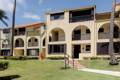 an exterior view of a building with palm trees at Carey Beach Villa in Humacao