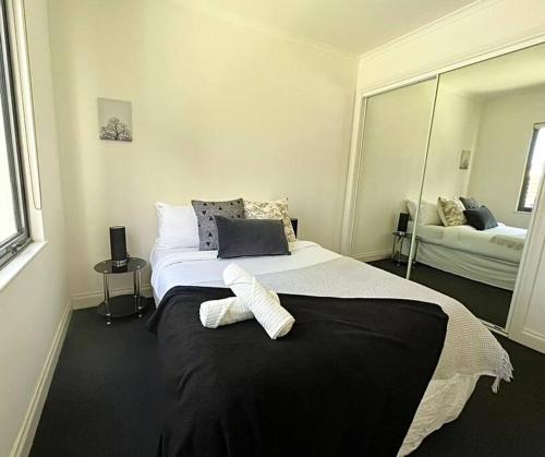1 dormitorio con 2 camas y un espejo grande en A Cozy 2B2B Apt Next To Carlton Garden W/ Parking, en Melbourne