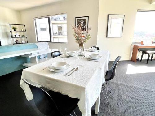a dining room with a white table and chairs at A Cozy 2B2B Apt Next To Carlton Garden W/ Parking in Melbourne