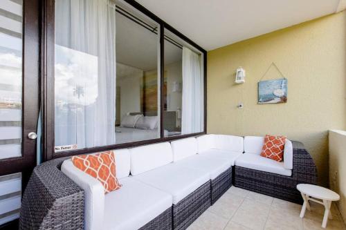 a living room with a white couch and a window at Carey Beach Villa in Humacao