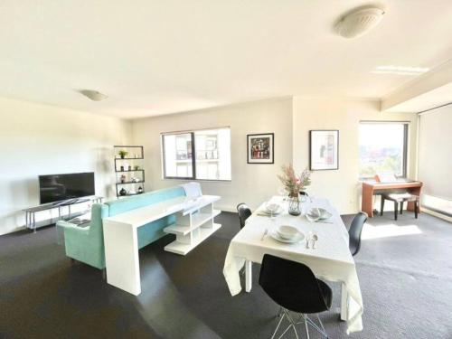 sala de estar con sofá azul y mesa en A Cozy 2B2B Apt Next To Carlton Garden W/ Parking, en Melbourne