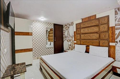 um quarto com uma cama branca e uma cabeceira em madeira em Mishra residency em Amritsar