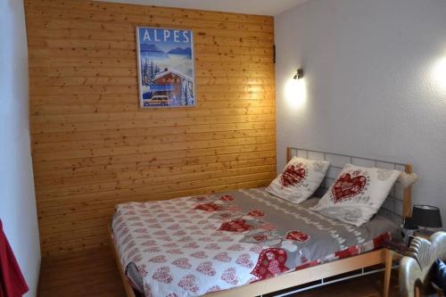 - une chambre avec un lit et un mur en bois dans l'établissement Orelle 3 vallées Studio 2 p, à Orelle
