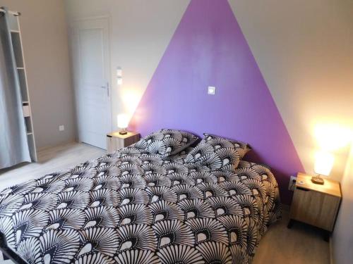 1 dormitorio con cama y pared púrpura en gite de la laiserie, en Mesnil-Clinchamps