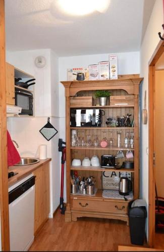 une cuisine avec une cabane en bois remplie d'articles dans l'établissement Orelle 3 vallées Studio 2 p, à Orelle