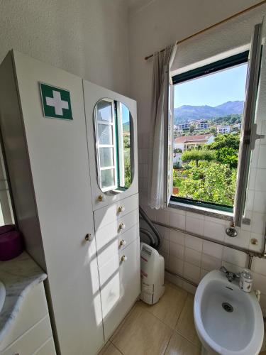 a bathroom with a toilet and a sink and a window at Casa Vista da Serra - Covilhã in Covilhã