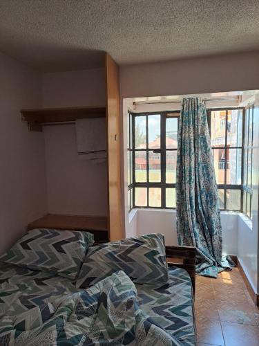 una camera con letto e finestra di Cottage 1 a Nairobi