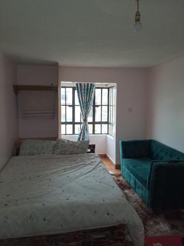 una camera con letto, divano e finestra di Cottage 1 a Nairobi