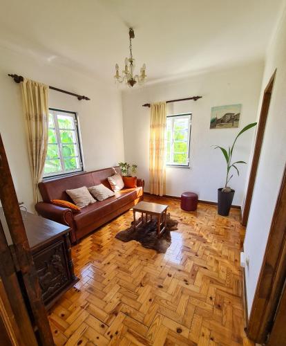 a living room with a couch and a wooden floor at Casa Vista da Serra - Covilhã in Covilhã