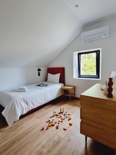 - une chambre avec un lit et quelques jouets à l'étage dans l'établissement Gîte Le Chambougeal avec spa privatif, à Lagraulière