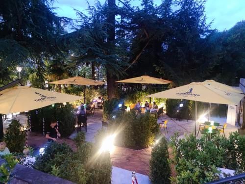 people sitting under umbrellas in a garden at night at BBConegliano Borlini in Conegliano