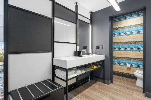 a bathroom with a sink and a toilet at Aloft Fort Lauderdale Airport in Fort Lauderdale