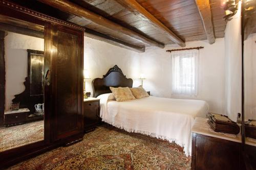 a bedroom with a large bed and a mirror at Casa Rural La Asomada in Vega de San Mateo