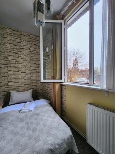 a bedroom with a bed and a large window at Riverside Baratashvili Apartment in Tbilisi City