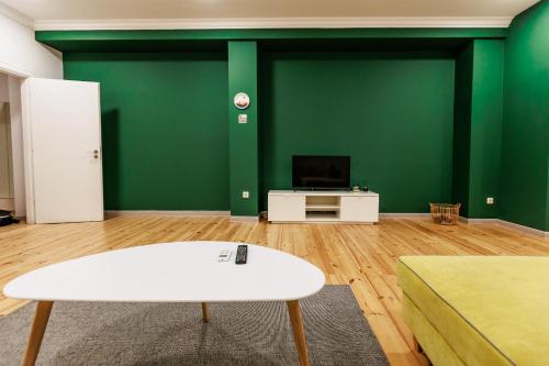 un soggiorno con pareti verdi e un tavolo bianco di A3 Delux Studio Saffron a Plovdiv