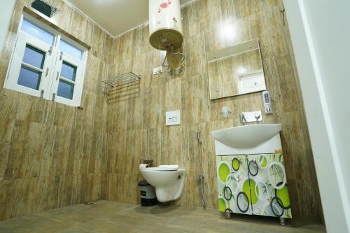 uma casa de banho com um lavatório e um WC em Nature's Edge Nishat Srinagar em Srinagar