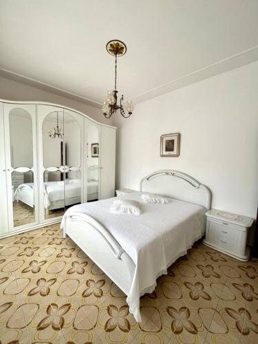 a white bedroom with a bed and a mirror at Casa Leonarda in Olmedo
