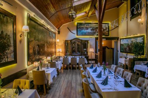 Un comedor con mesas blancas y sillas amarillas. en Euro Aparthotel, en Tarnów
