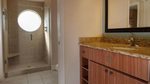 y baño con ducha, lavabo y espejo. en Westgate Town Resort en Orlando