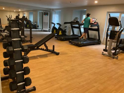 a woman is running on a treadmill in a gym at JNL Victoria Sports Towers condo - GMA, Quezon city in Manila