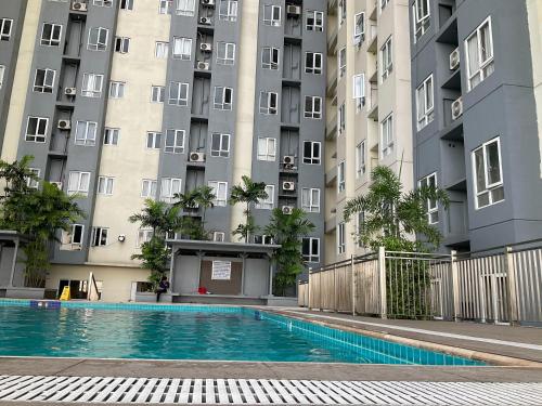 a swimming pool in front of a tall building at JNL Victoria Sports Towers condo - GMA, Quezon city in Manila