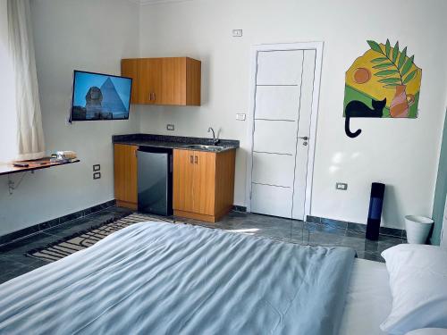 um quarto com uma cama e uma cozinha com um lavatório em Rafiki - Guest House em Cairo